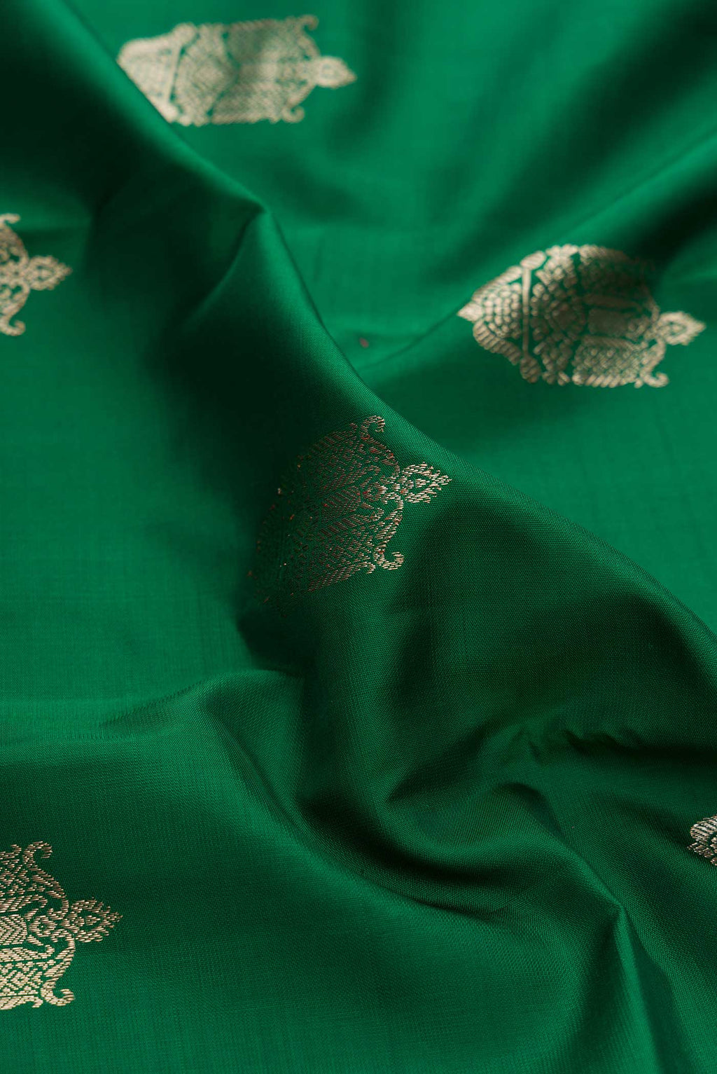Close up of Green Dual Tone Kanchipuram Silk Saree with Zari Butta on the body and Zari Border displaying folds