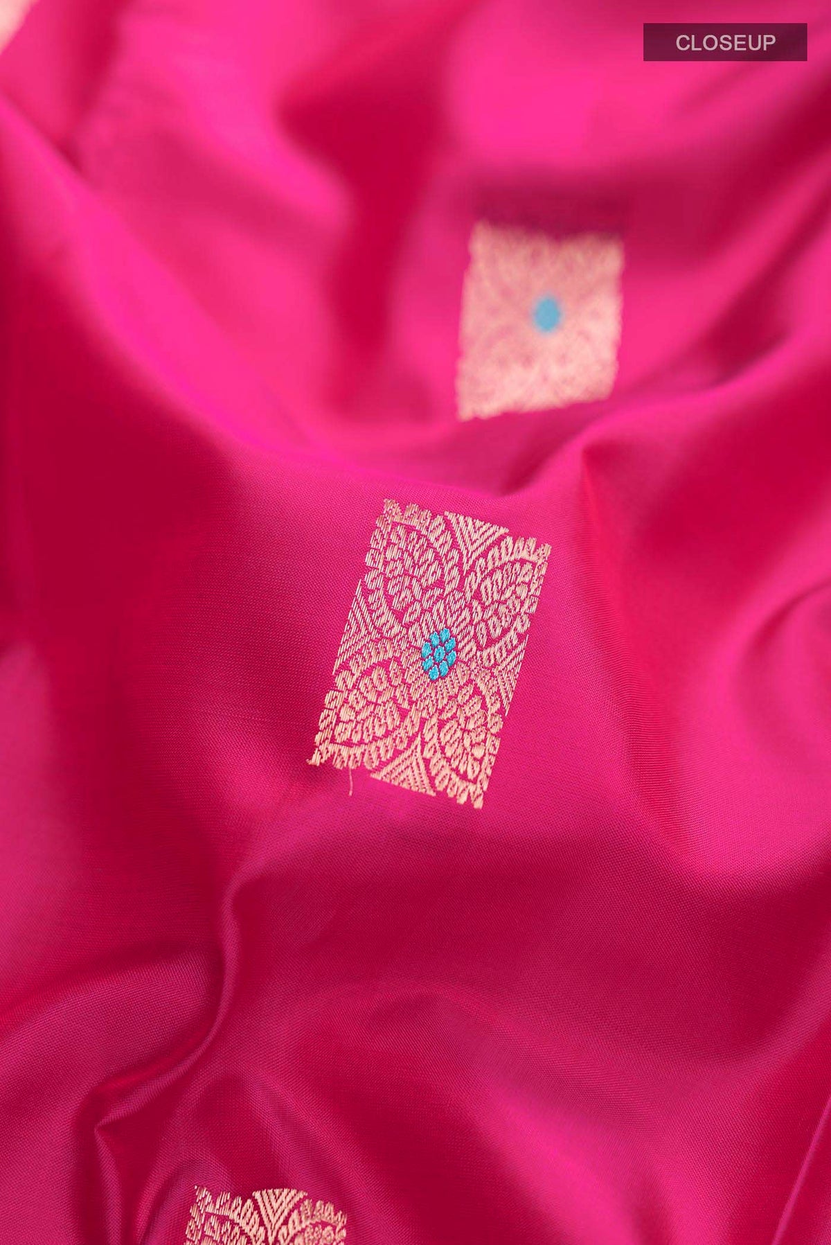 Close up of Pink Kanchipuram Silk Saree with Zari Butta on the body and Zari Border displaying folds