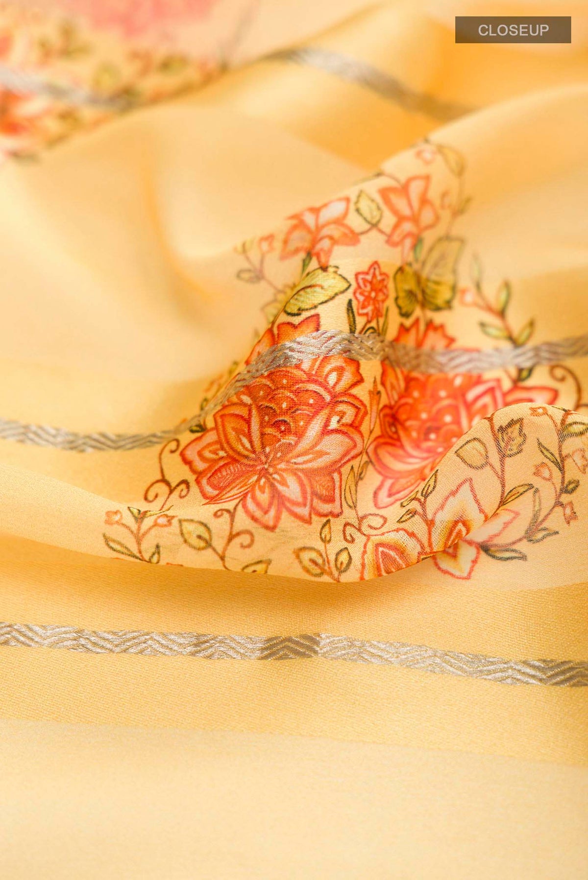 Close up of Yellow Mysore Georgette Saree Printed design on the body and Zari Border displaying folds