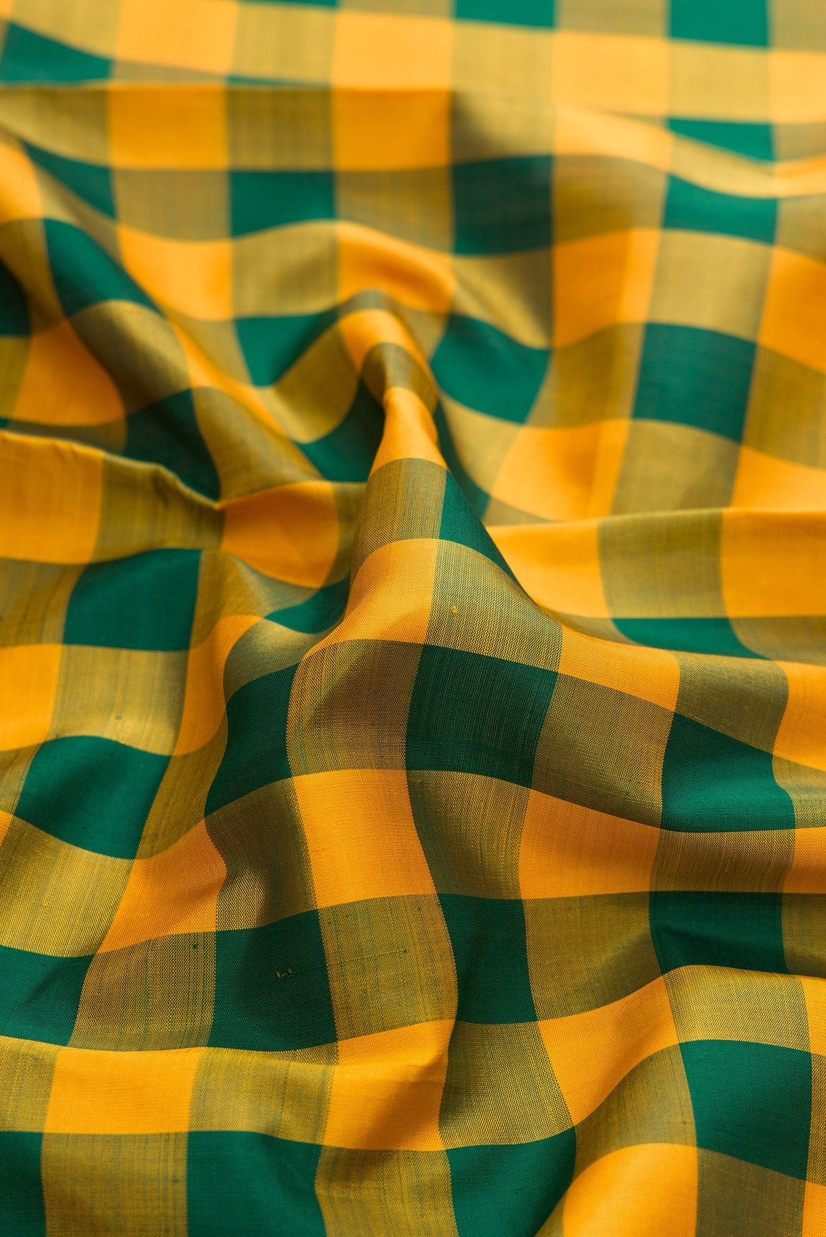 Close up of Pure Silk Pure Zari Green and Mustard Color Kanjivaram Saree with Checked design on the body and Zari Border.  displaying folds