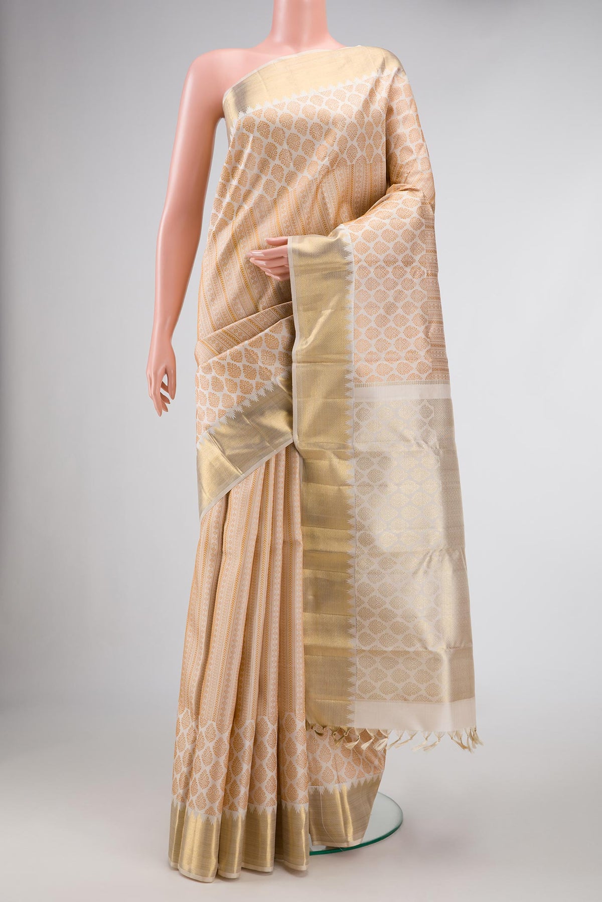 Beige Dual Tone Kanchipuram Silk Saree with Zari Butta on the body and Zari Border.  displayed on a mannequin