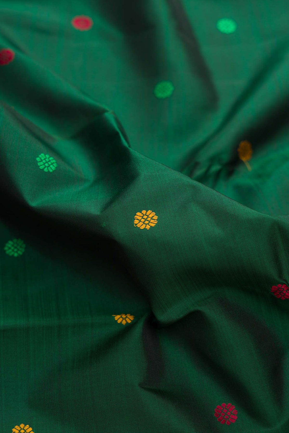 Close up of Bottle Green Dual Tone Kanchipuram Silk Saree with Thread Butta on the body and Zari Border displaying folds