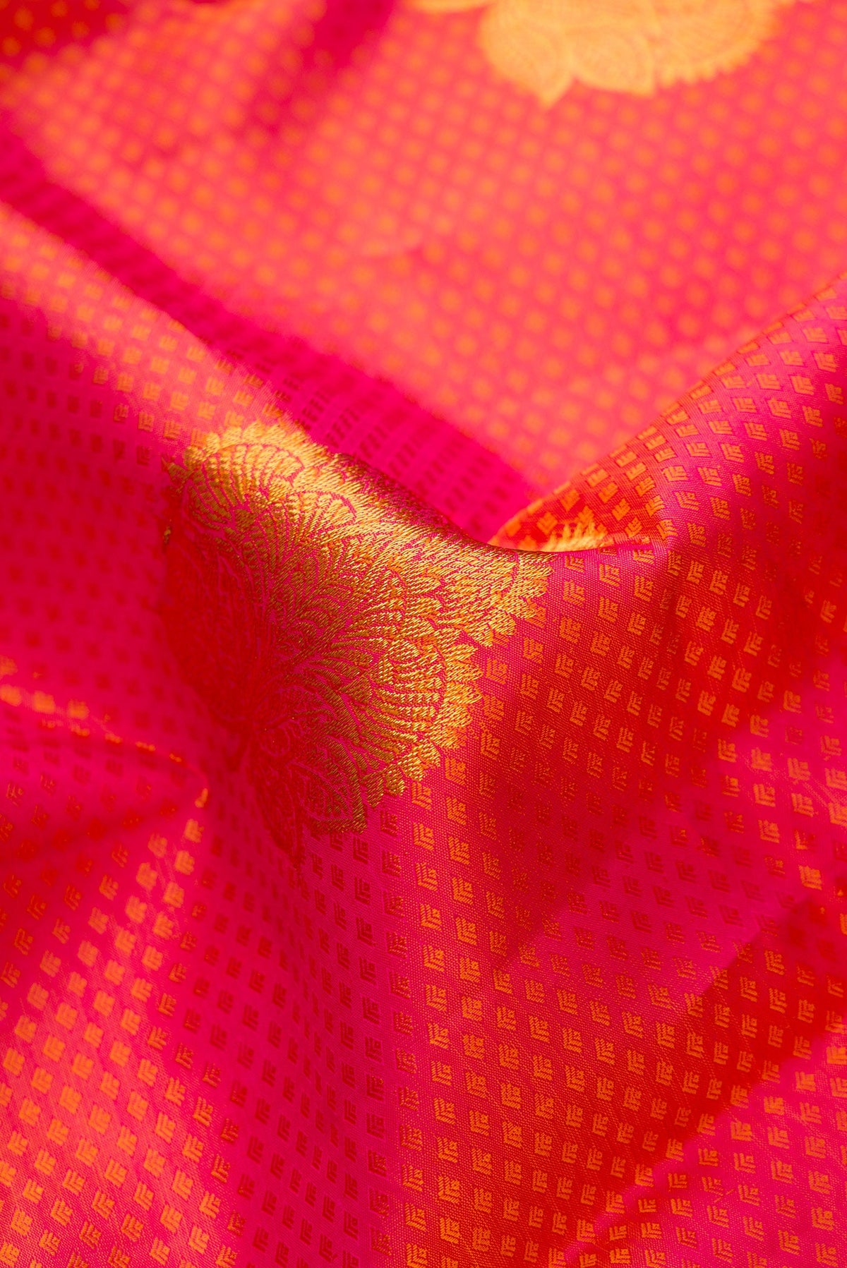 Close up of Dark Pink Dual Tone Kanchipuram Silk Saree with Jacquard With Zari Butta on the body and Zari Border.  displaying folds
