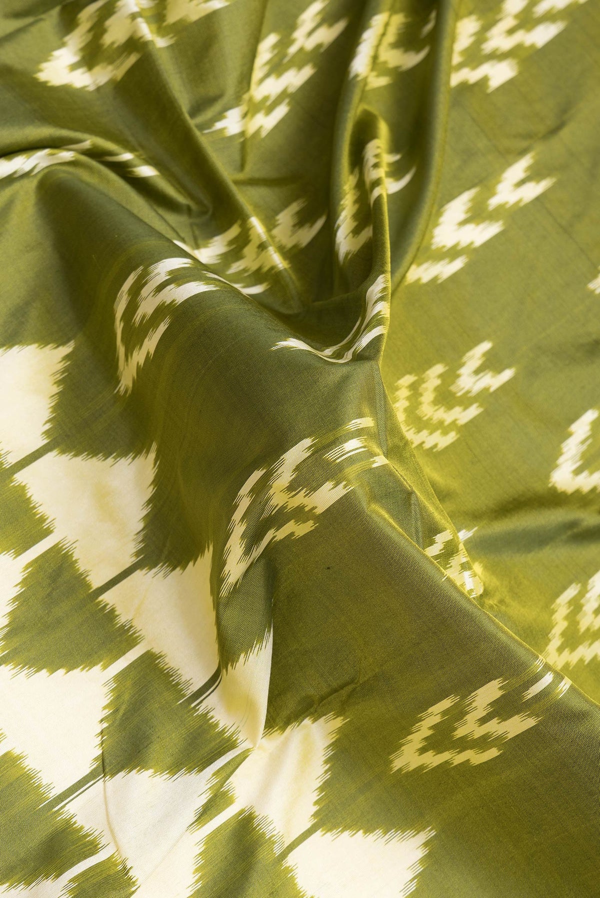 Close up of Mehandi Green Dual Tone Double Ikat Saree with Ikat Print on the body and Ikat Border.  displaying folds