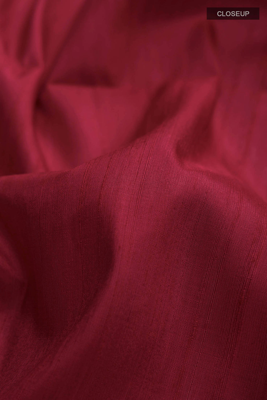 Close up of Maroon Raw Silk Saree with Plain Body and Zari Border displaying folds