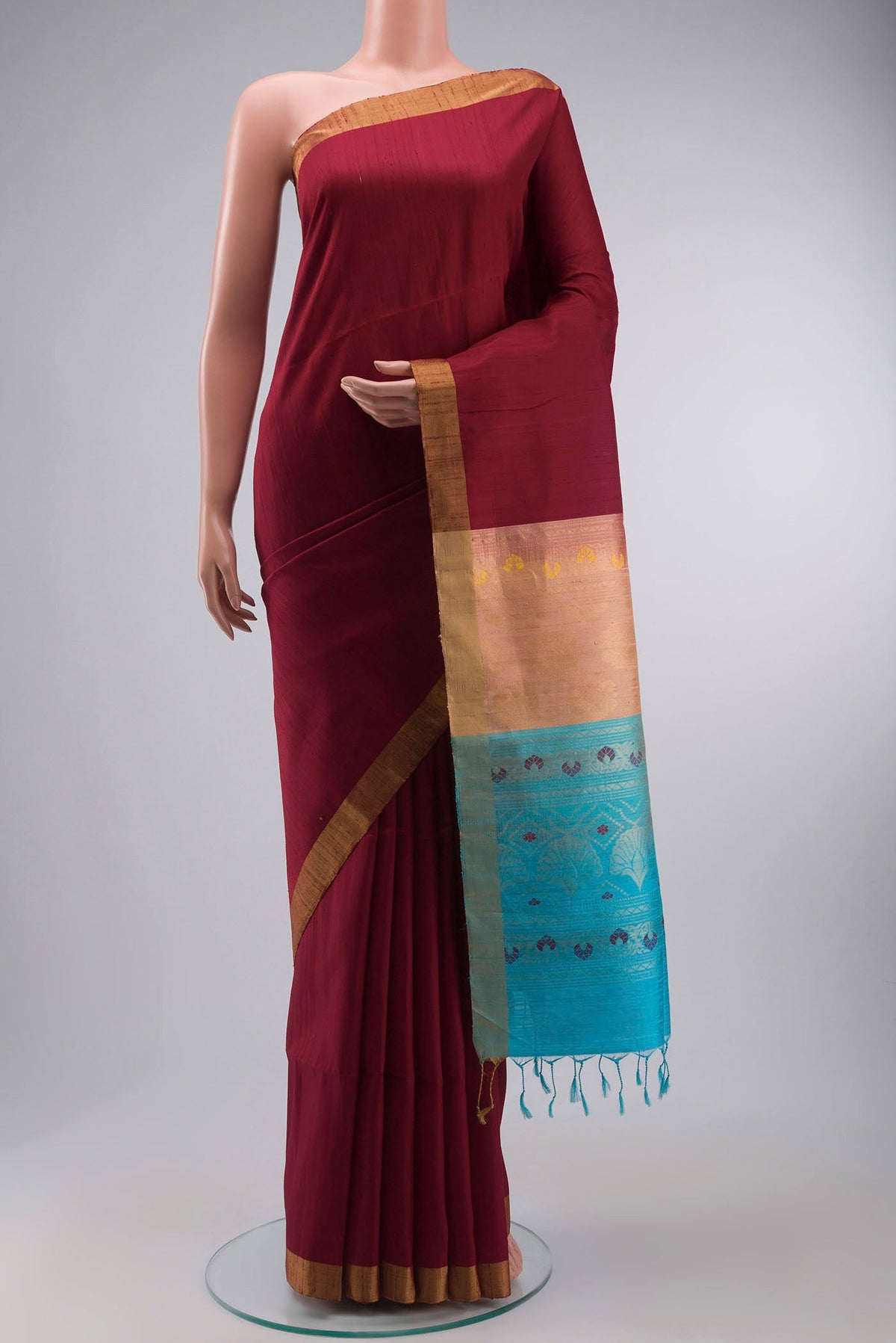 Maroon Raw Silk Saree with Plain Body and Zari Border displayed on a mannequin