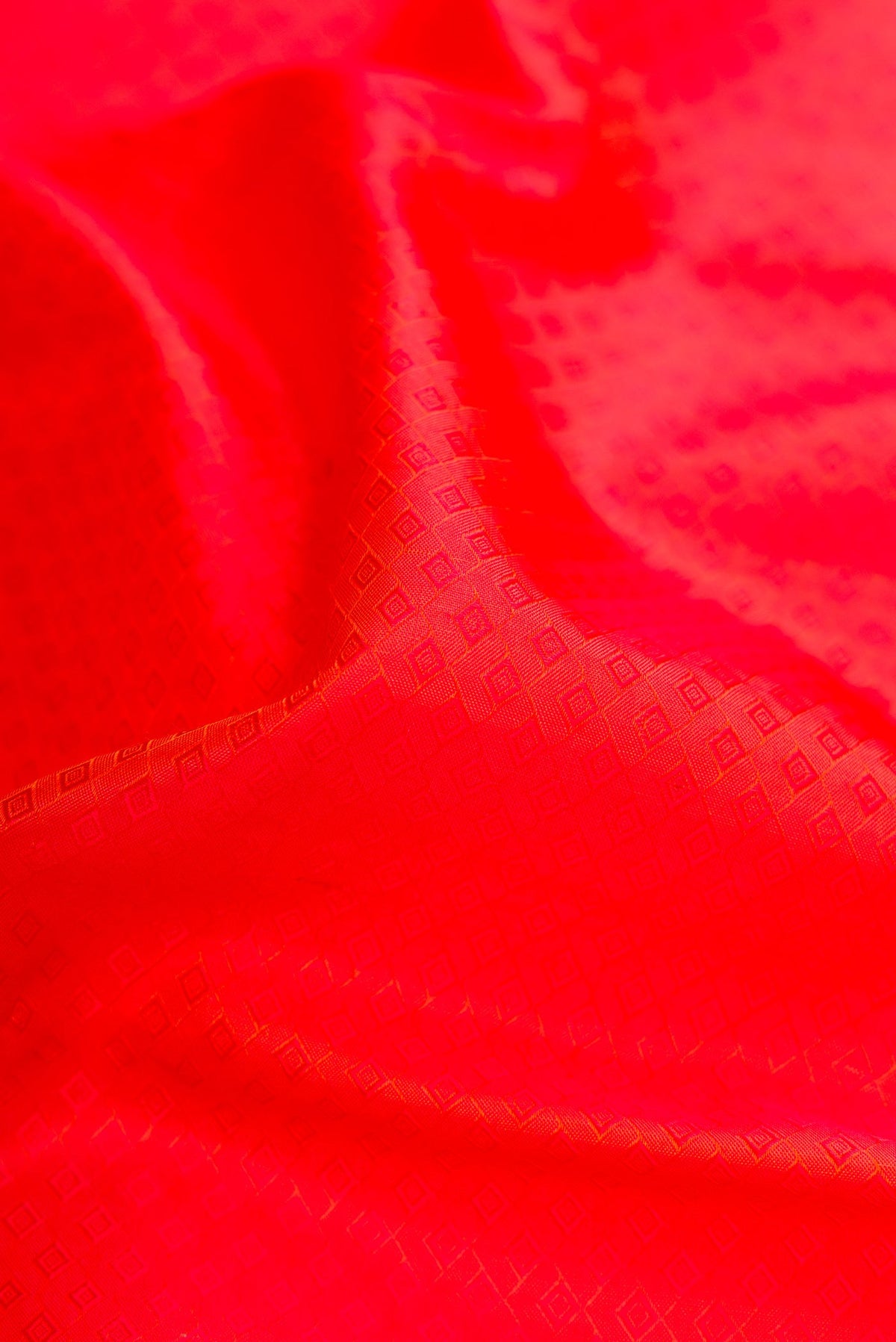 Close up of Orange Dual Tone Kanchipuram Silk Saree with Jacquard design on the body and Zari And Thread Border.  displaying folds