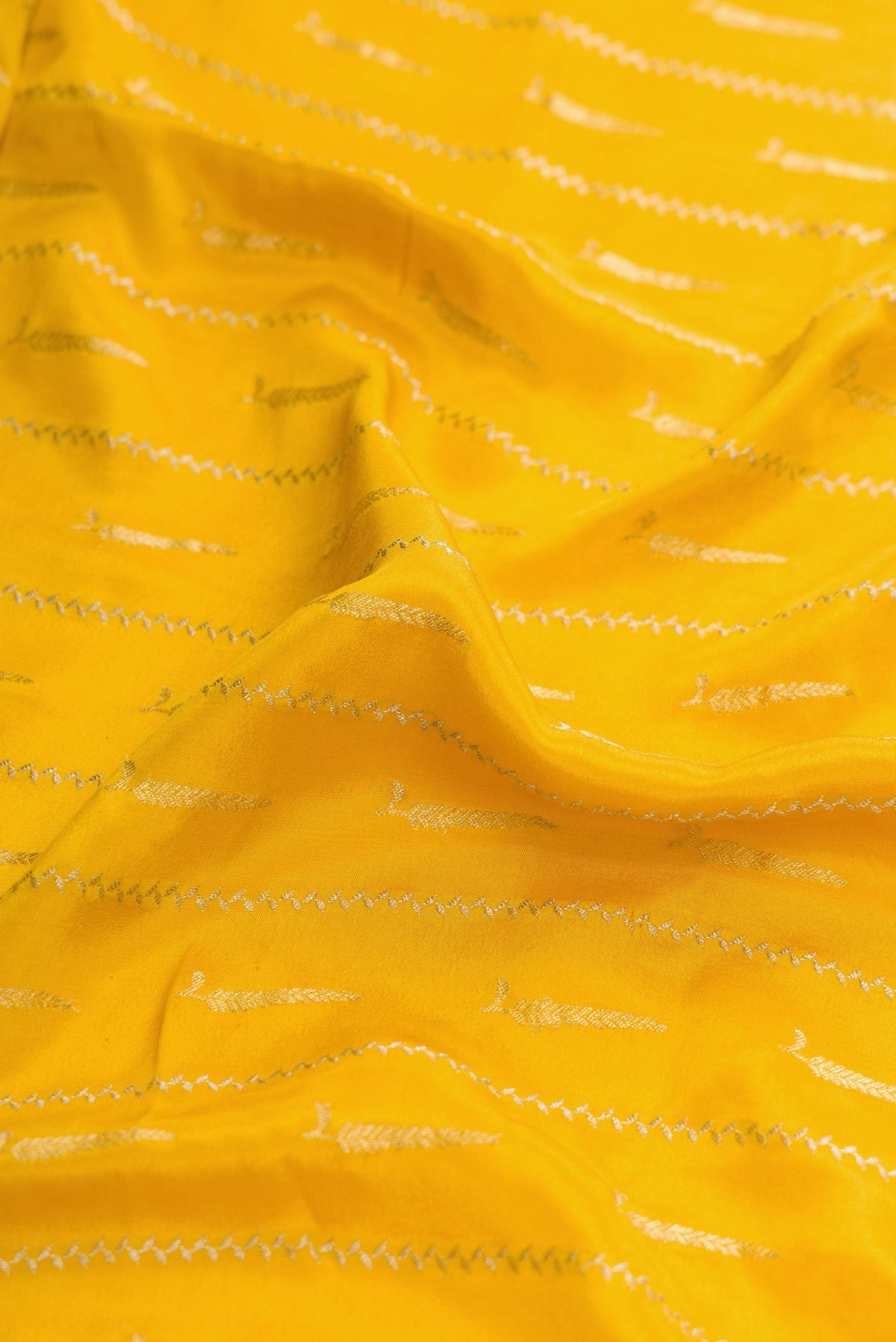 Close up of Mustard Dual Tone Mysore Georgette Saree with Stripes on the body and Zari And Thread Border.  displaying folds