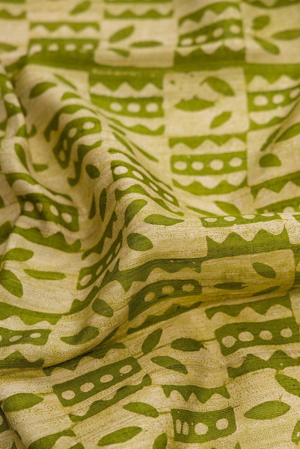 Close up of Mehandi Green Dual Tone Tussar Silk Saree with Printed design on the body and Fancy Border.  displaying folds