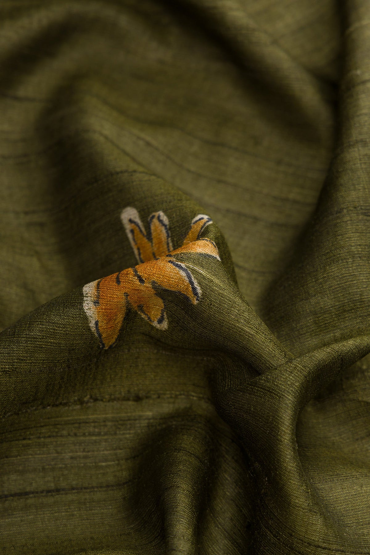 Close up of Green Dual Tone Tussar Silk Saree with Printed design on the body and Plain Border.  displaying folds