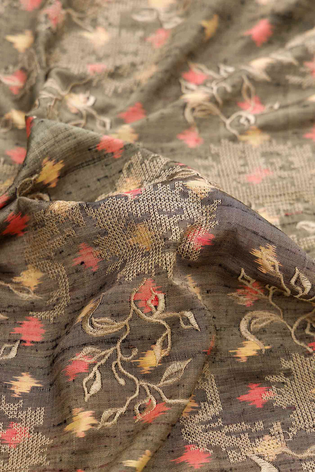 Close up of Grey Dual Tone Rajkot Patola Silk Saree with Ikat Print on the body and Zari Border displaying folds