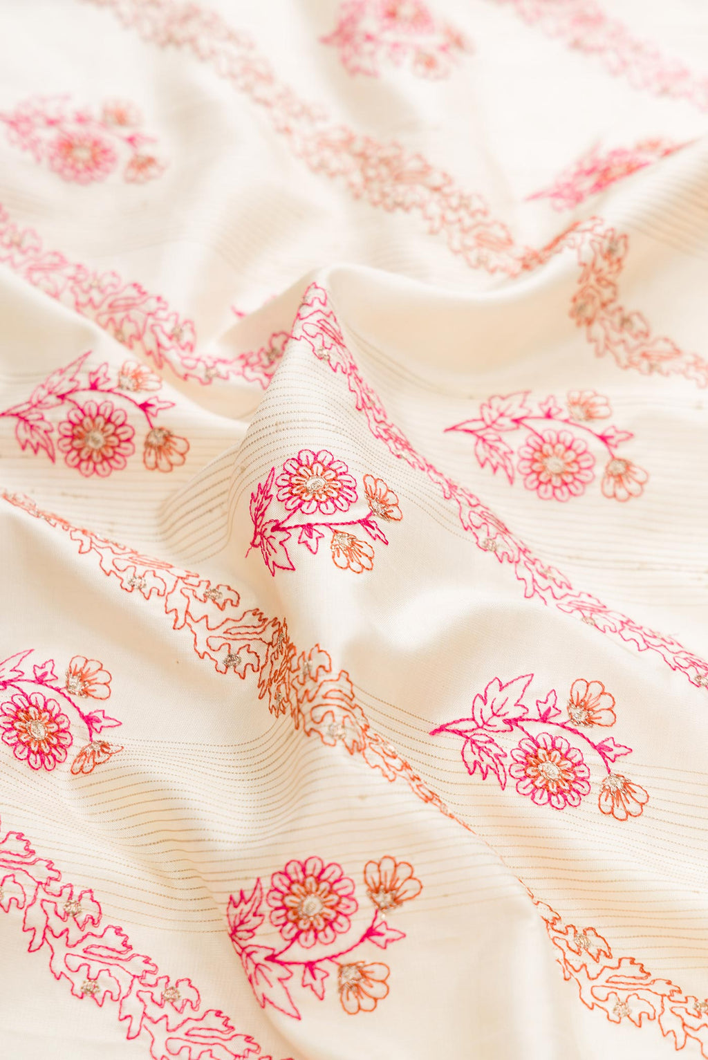 Close up of Off White Soft Silk Saree with Embroidery on the body and Plain Border displaying folds