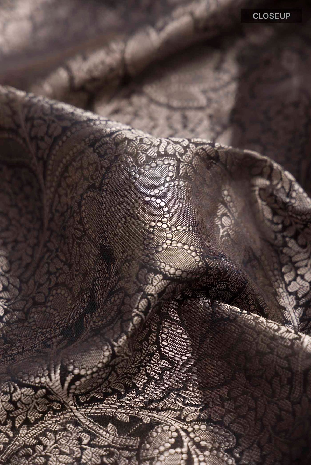 Close up of Black Banarasi Silk Saree with Zari Brocade on the body and Printed Border displaying folds