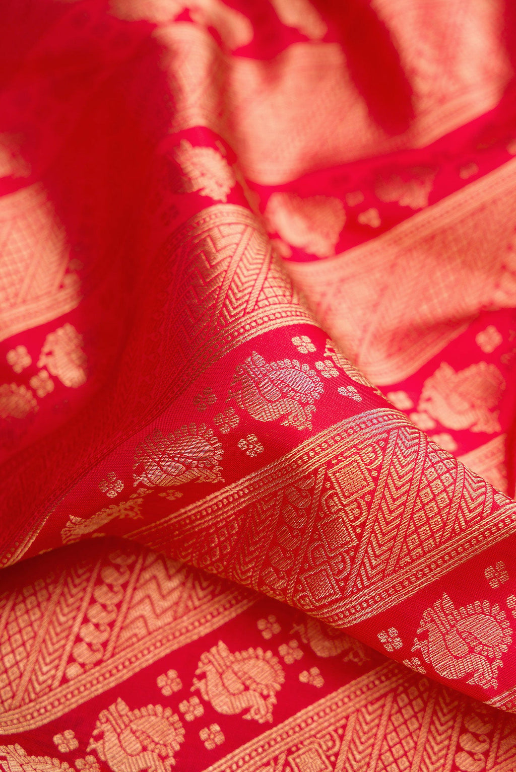 Close up of Red Kanchipuram Silk Saree with Zari Brocade on the body and Zari Border.  displaying folds
