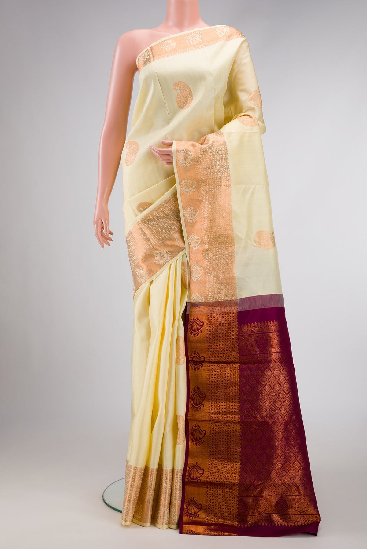 Sandal Dual Tone Kanjivaram Silk Saree with Zari Butta on the body and Zari Border.  displayed on a mannequin