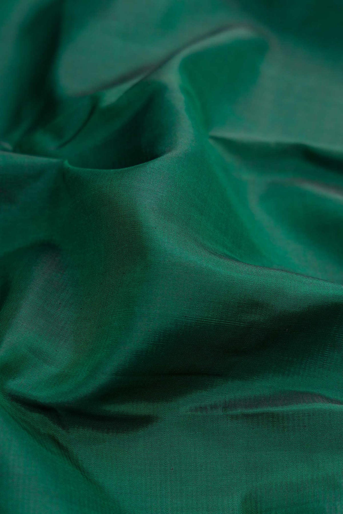 Close up of Bottle Green Dual Tone Kanchipuram Silk Saree with Plain Body and Zari Border.  displaying folds