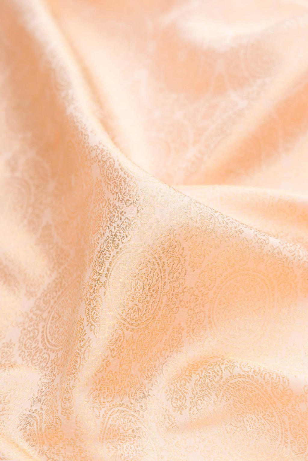 Close up of Golden Peach Dual Tone Kanchipuram Silk Saree with Zari Brocade on the body and Zari Border displaying folds
