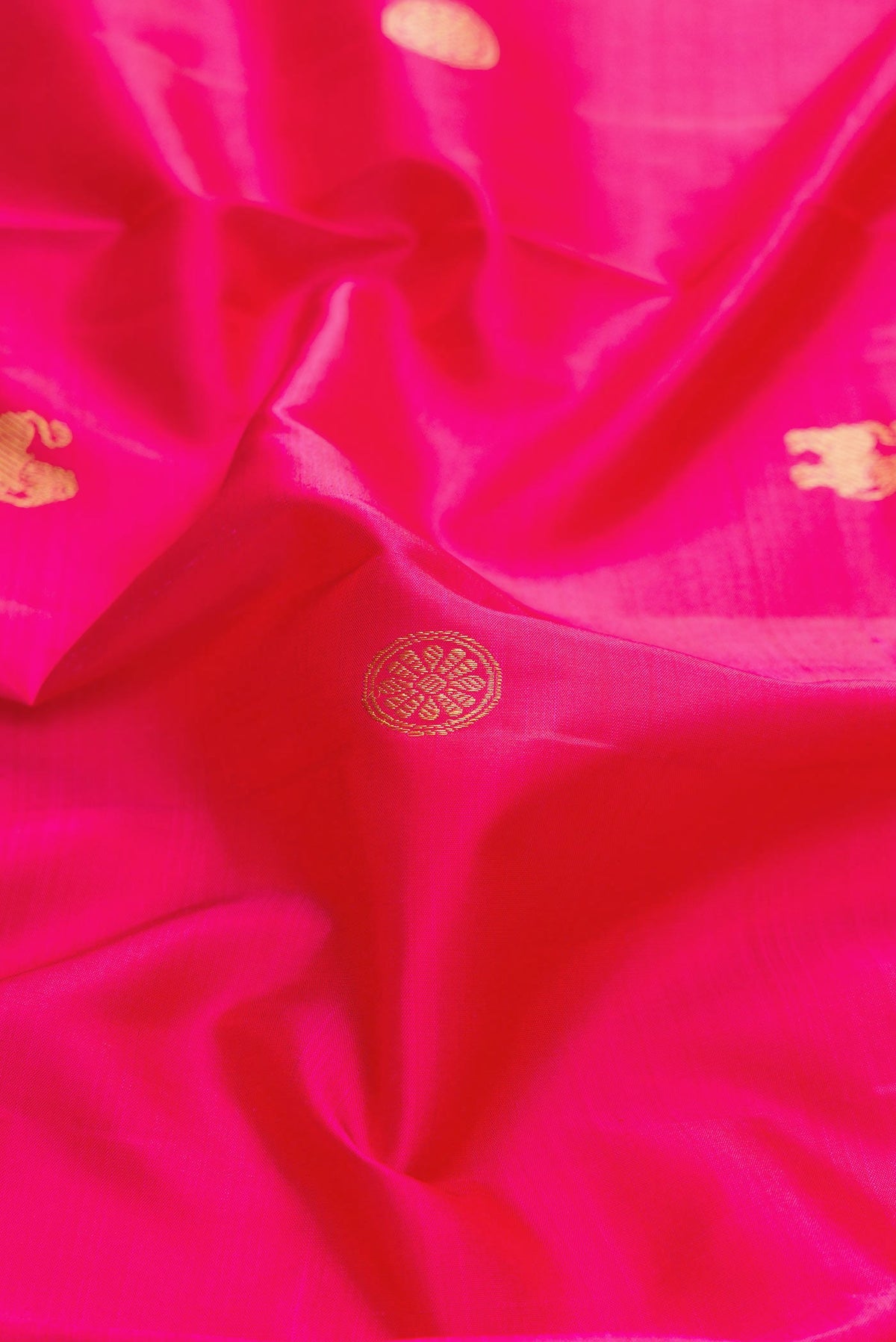 Close up of Dark Pink Dual Tone Kanchipuram Silk Saree with Zari Butta on the body and Zari Border displaying folds