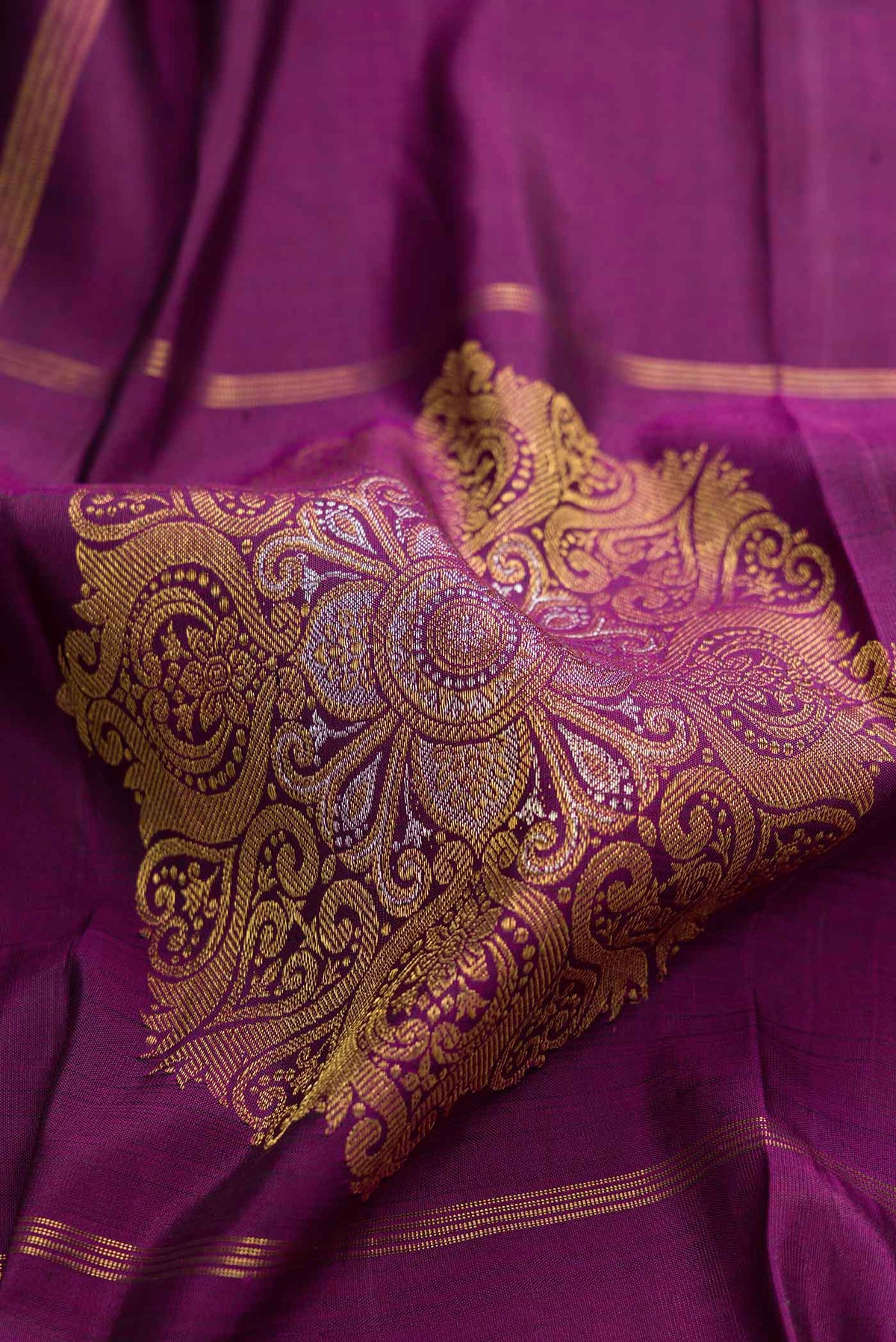 Close up of Purple Dual Tone Kanchipuram Silk Saree With Checked design on the body and Zari Border displaying folds