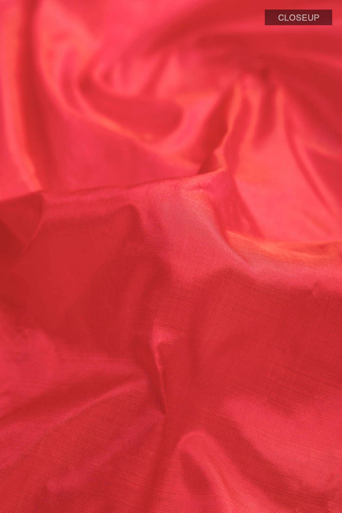 Close up of Orange Kanchipuram Silk Saree with Plain Body and Thread Border displaying folds