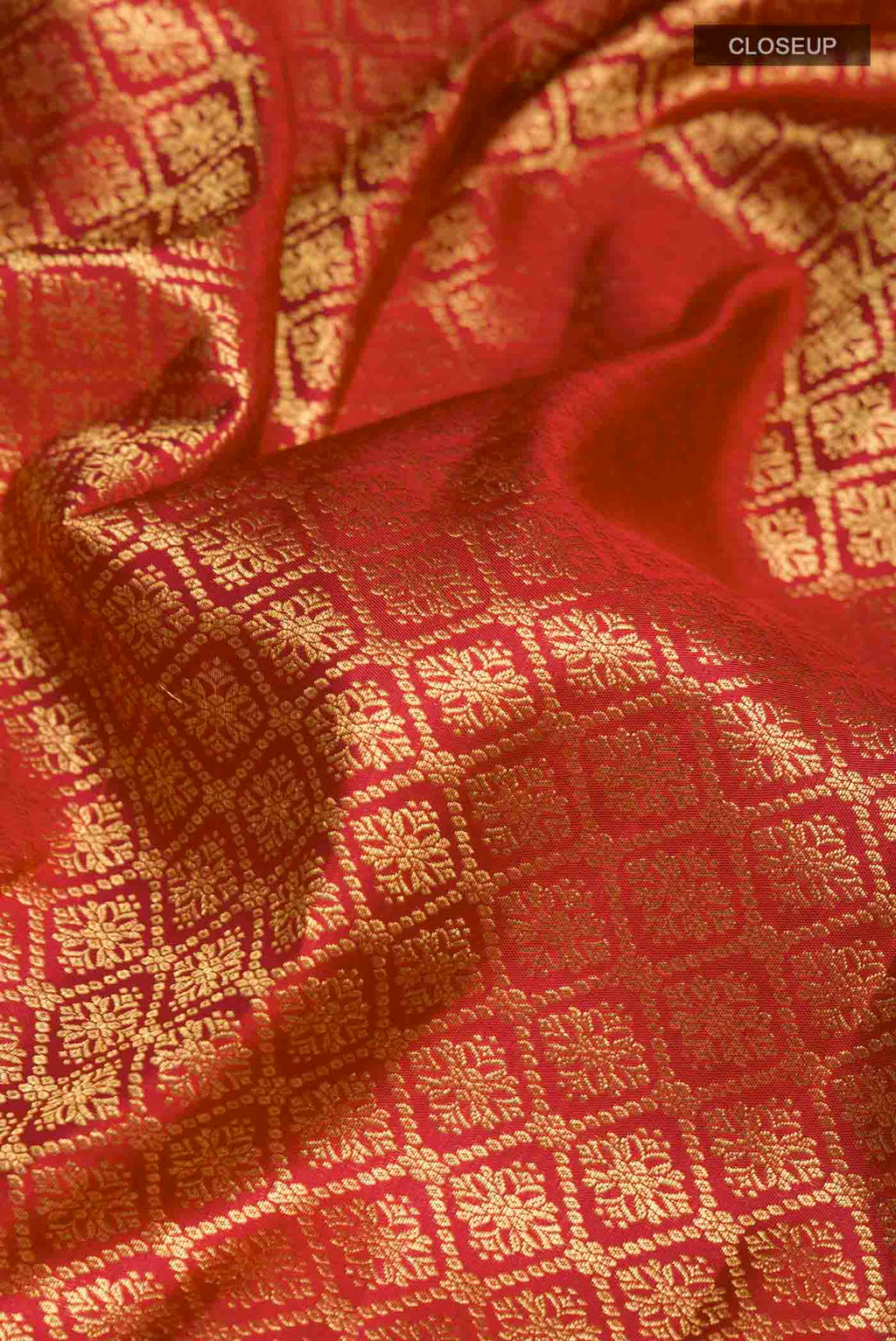 Close up of Maroon Kanchipuram Silk Saree with Zari Butta on the body and Zari Border displaying folds