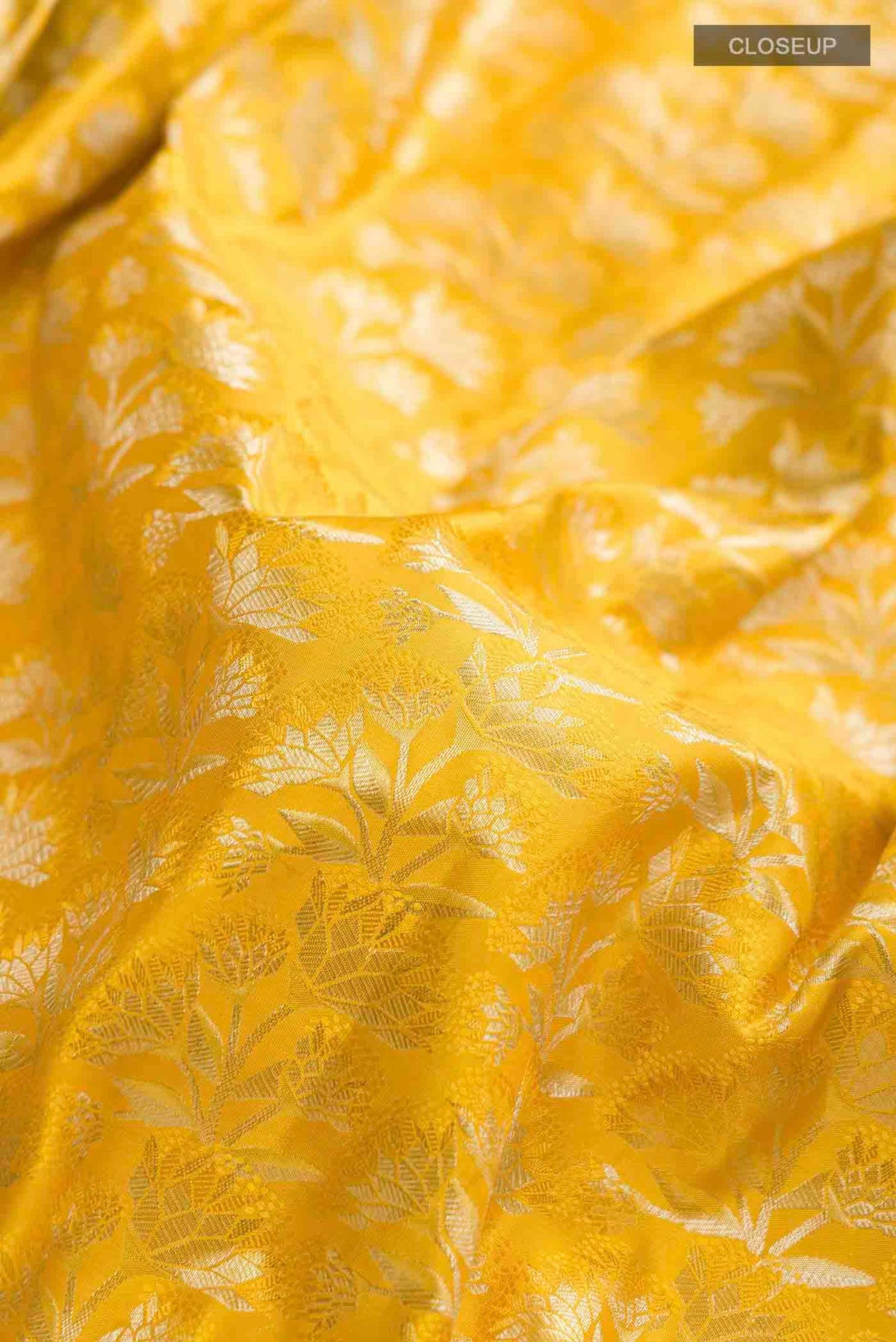 Close up of Yellow Kanchipuram Silk Saree with Zari Brocade on the body and Zari Border displaying folds