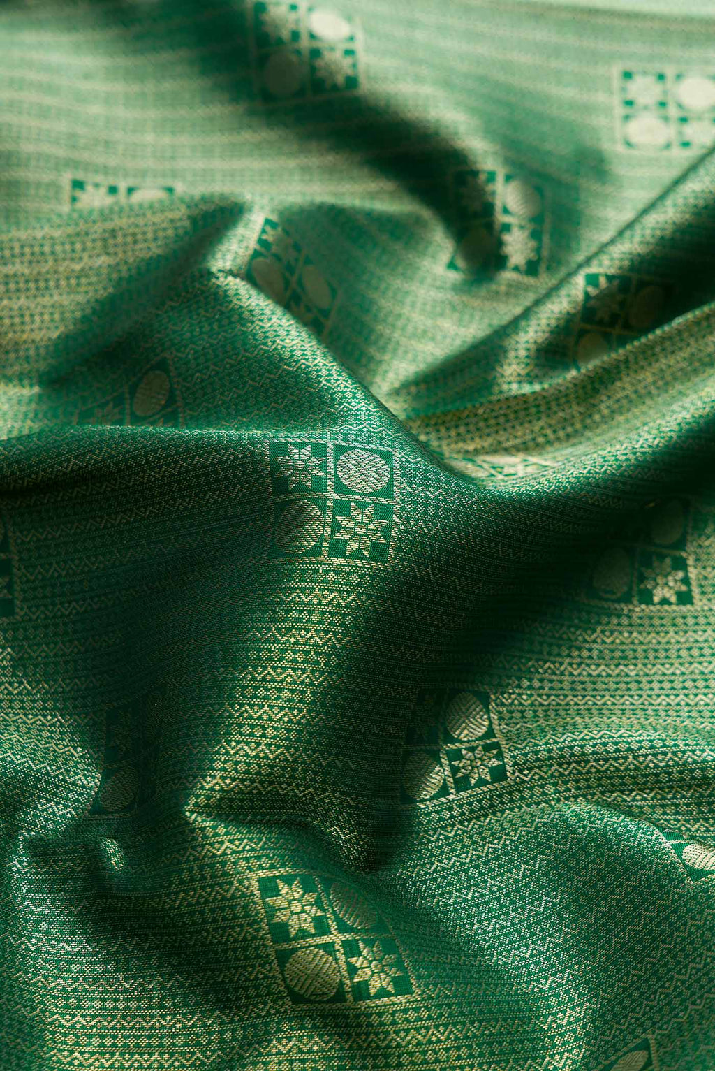 Close up of Green Dual Tone Kanchipuram Silk Saree with Zari Brocade on the body and Zari Border displaying folds