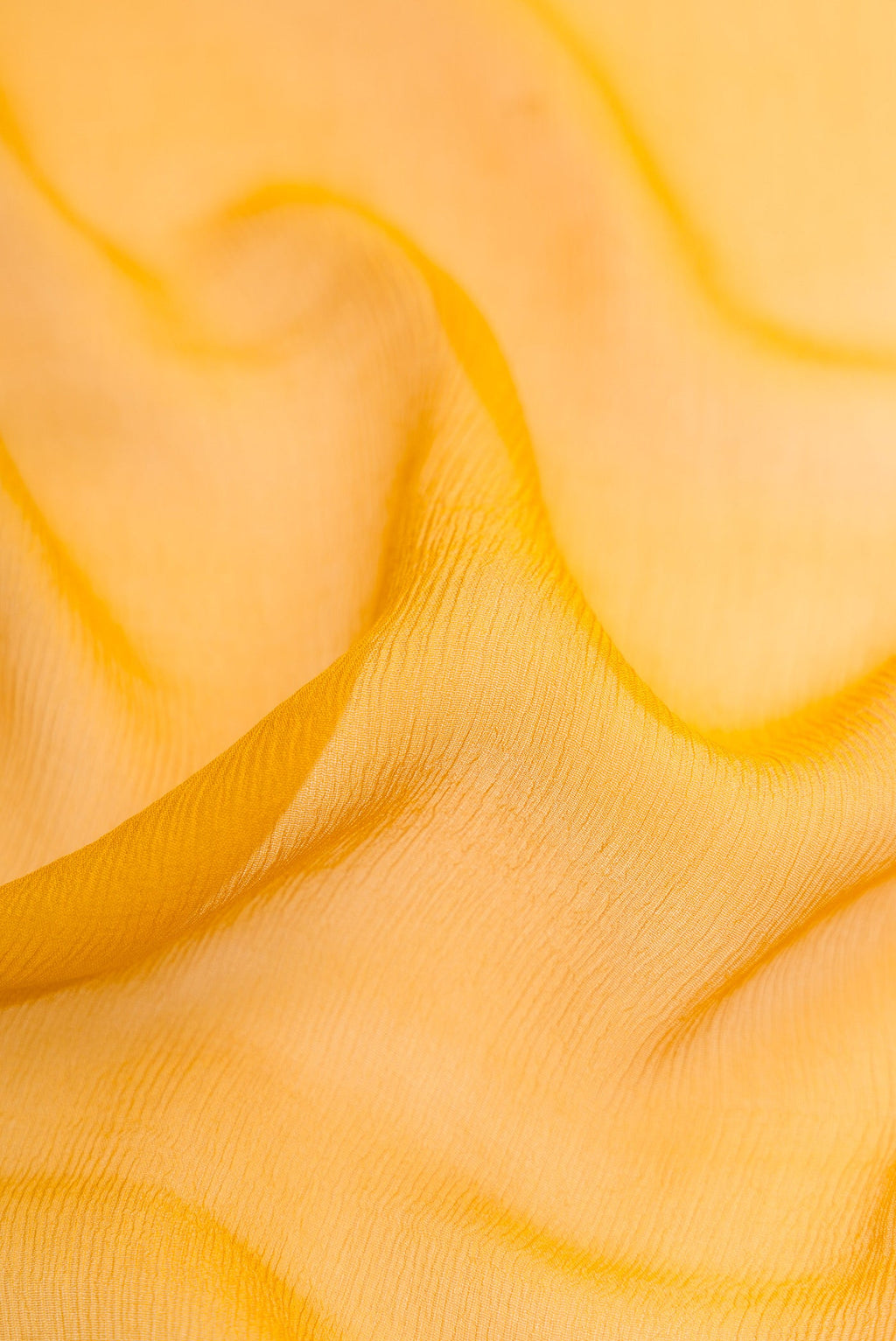 Close up of Mustard Mysore Chiffon Saree with Plain Body and Zari Border.  displaying folds