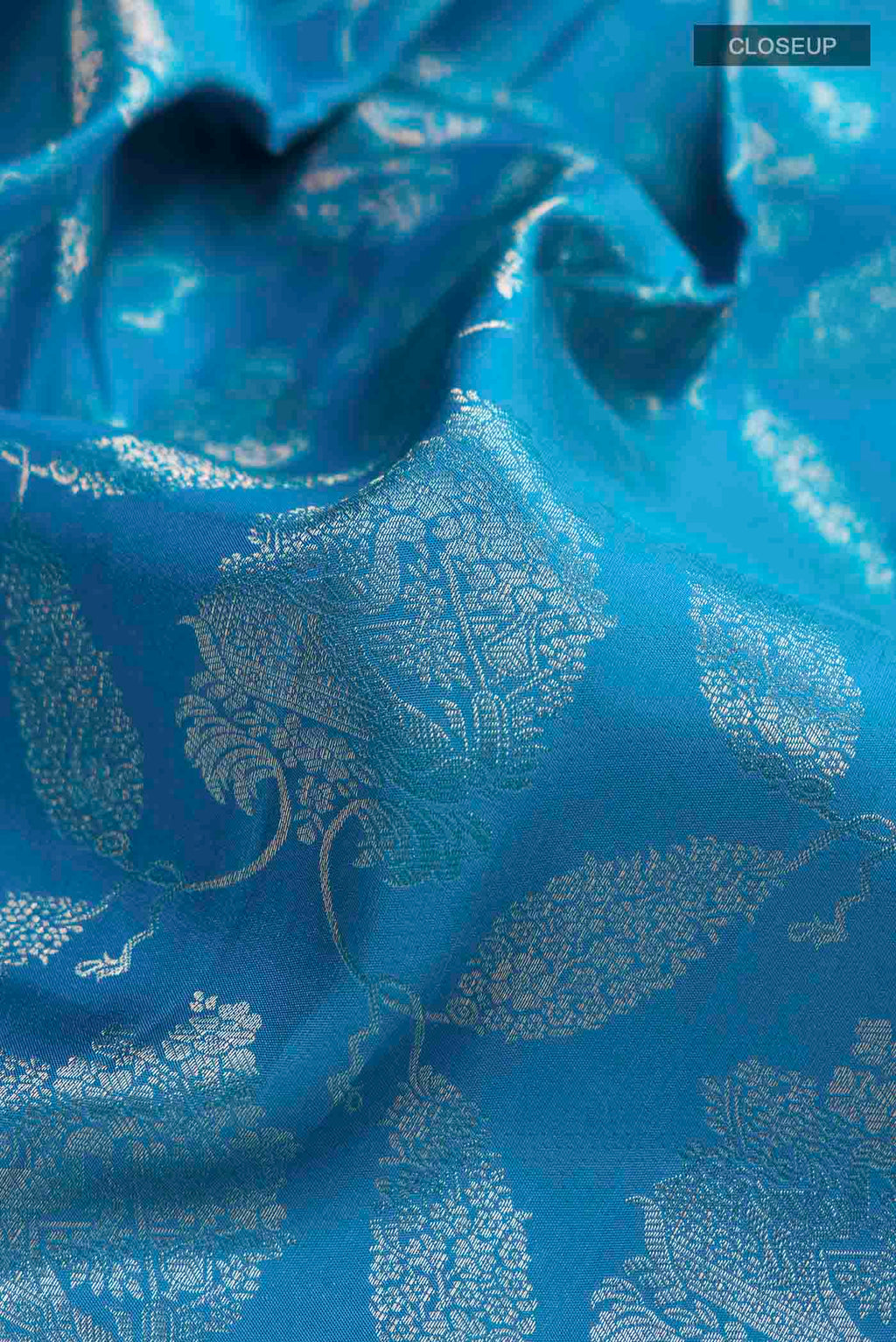 Close up of Blue Kanchipuram Silk Saree with Zari Butta on the body and Zari Border displaying folds
