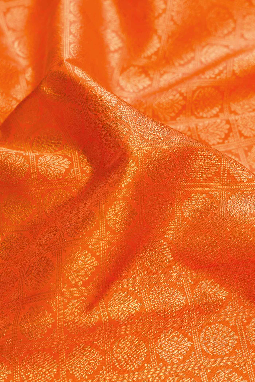 Close up of Pure Silk Pure Zari Orange Dual Tone Kanchipuram Saree with Zari Brocade on the body and Zari Border displaying folds