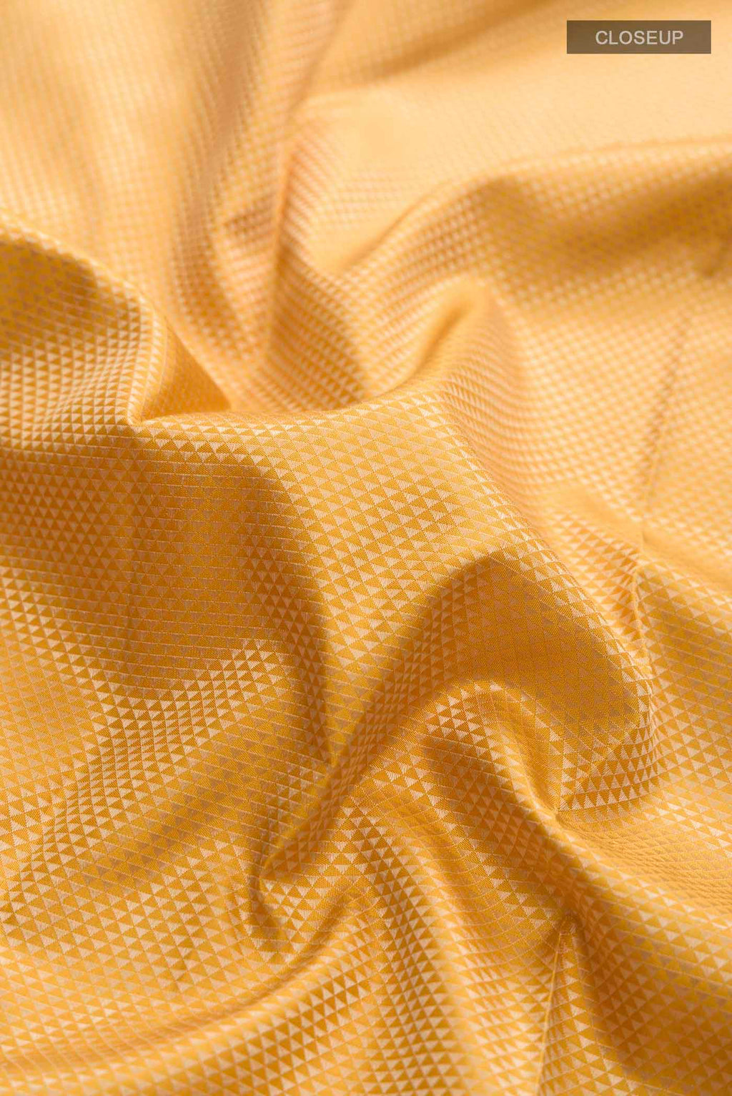 Close up of Yellow Kanchipuram Silk Saree with Jacquard design on the body and Thread Border displaying folds