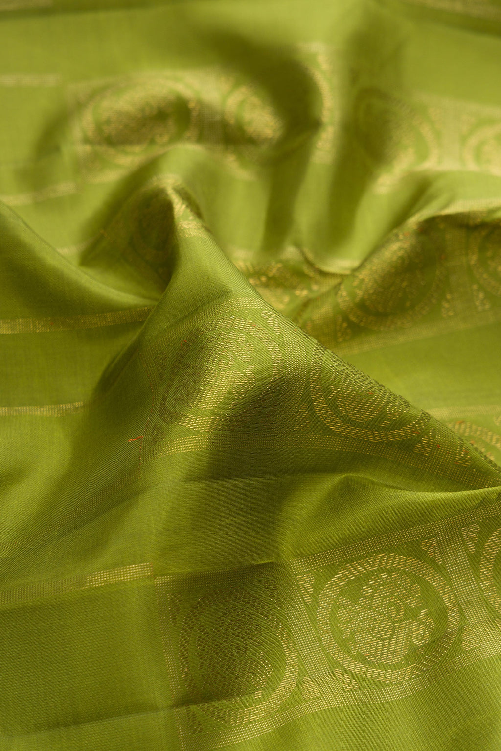 Close up of Pure Silk Pure Zari Green Dual Tone Kanjivaram Saree with Zari Butta on the body and Without Border.  displaying folds