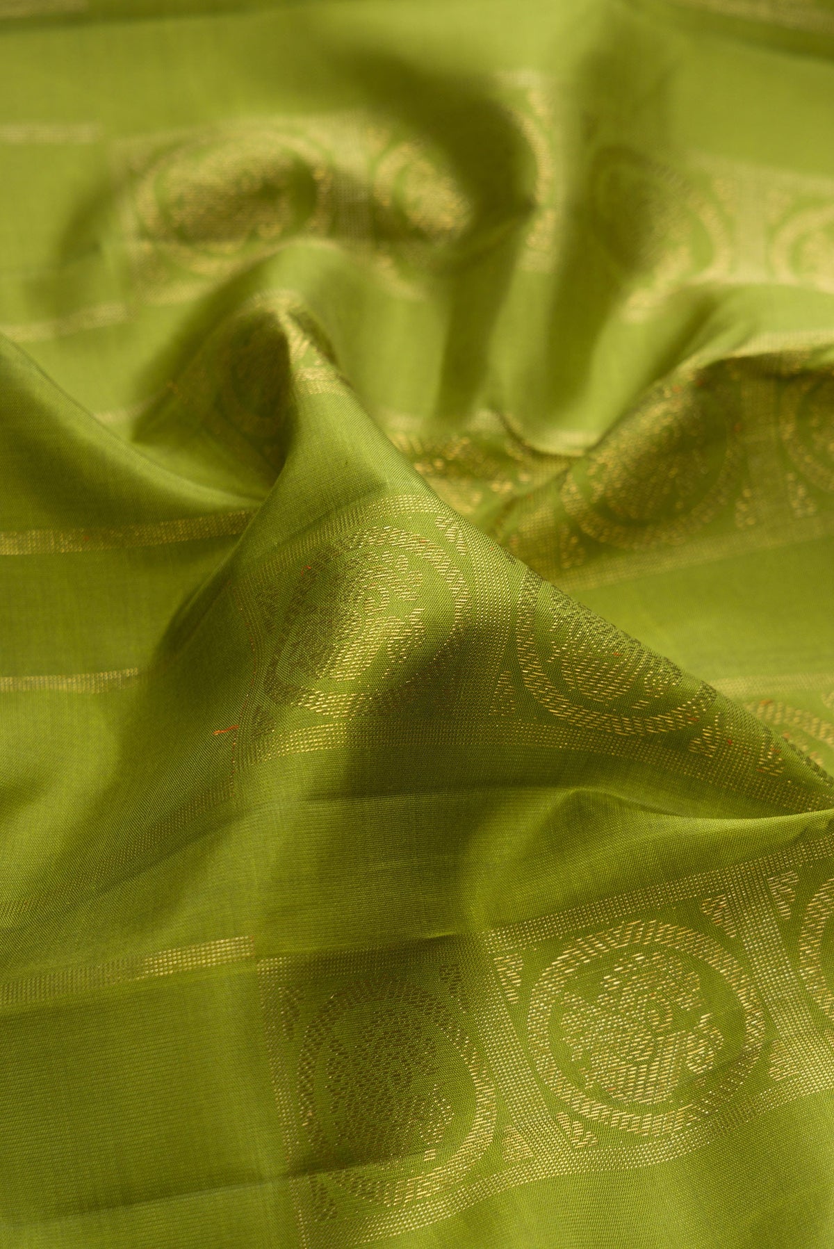 Close up of Pure Silk Pure Zari Green Dual Tone Kanjivaram Saree with Zari Butta on the body and Without Border.  displaying folds