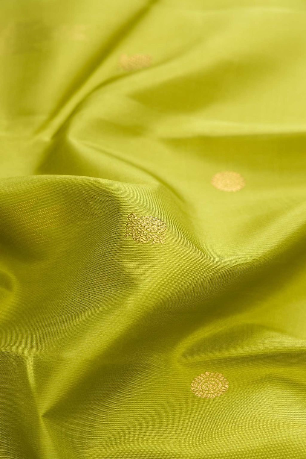 Close up of Pure Silk Pure Zari Parrot Green Dual Tone Kanchipuram Saree with Zari Butta on the body and Plain Border displaying folds