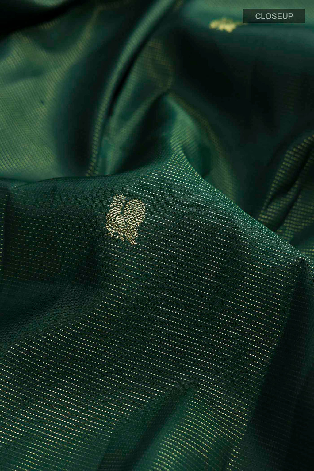 Close up of Green Kanchipuram Silk Saree with Zari Butta on the body and Zari Border displaying folds