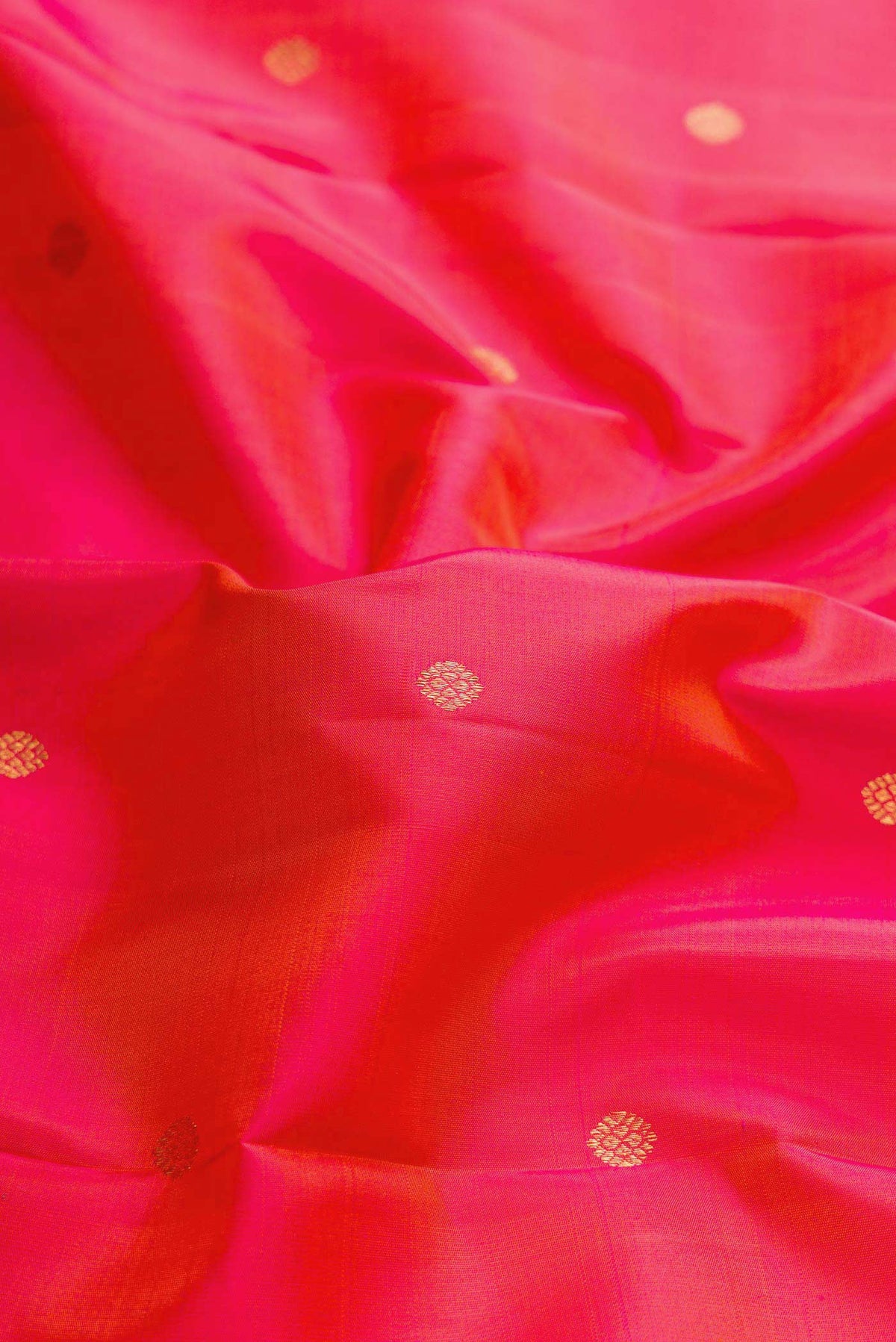 Close up of Dark Pink Dual Tone Kanchipuram Silk Saree with Zari Butta on the body and Zari Border displaying folds