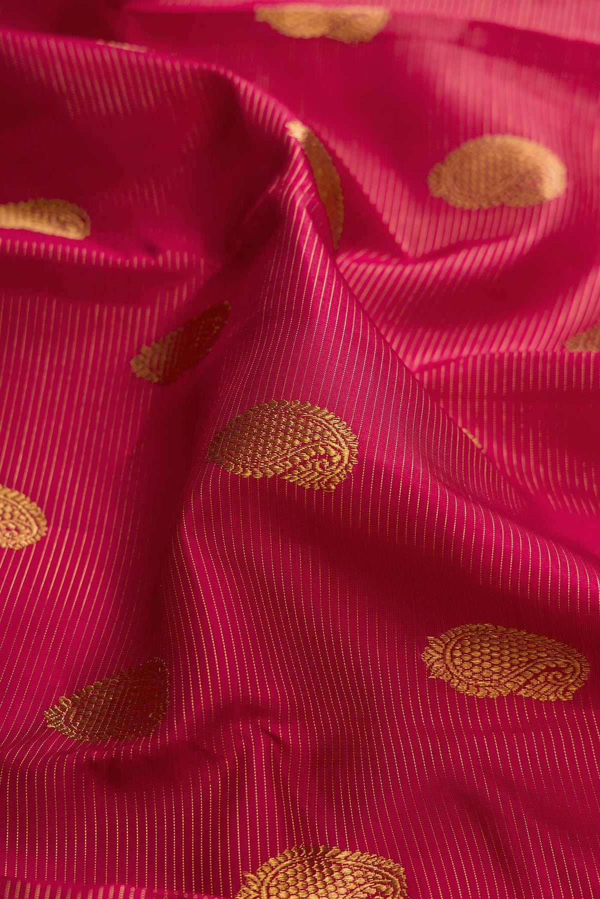 Close up of Pure Silk Pure Zari Red Dual Tone Kanchipuram Saree with Zari Butta on the body and Zari Border displaying folds
