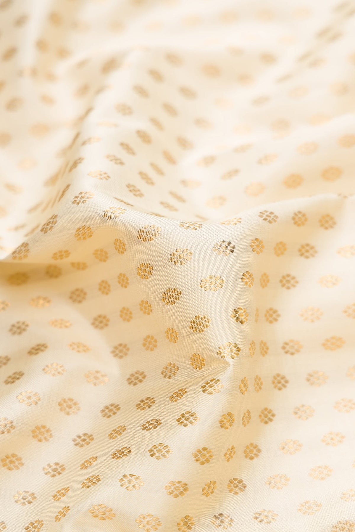 Close up of Off White Dual Tone Kanchipuram Silk Saree with Zari Brocade on the body and Zari Border displaying folds