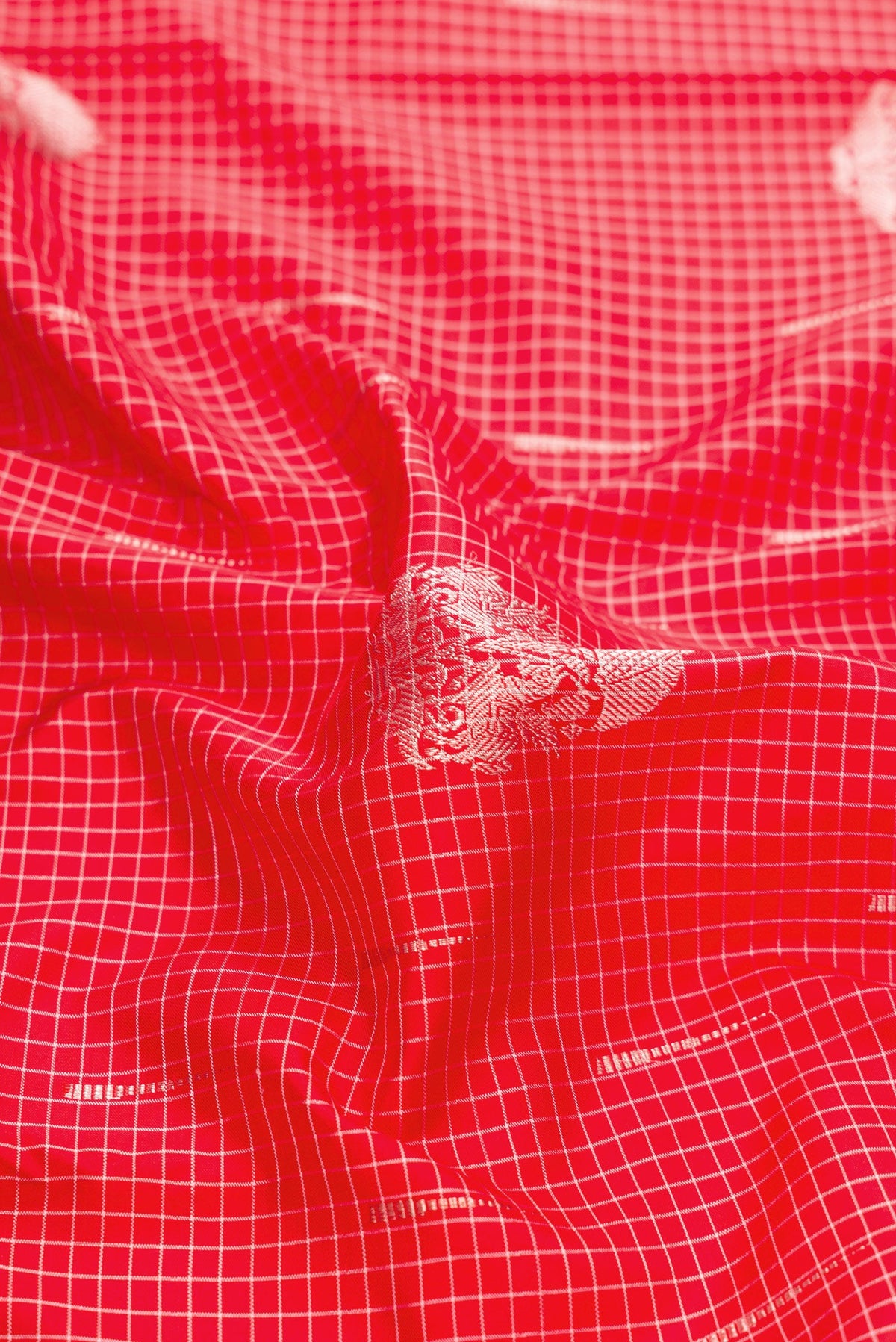 Close up of Pure Silk Pure Zari Red Dual Tone Kanjivaram Saree with Zari Butta on the body and Without Border.  displaying folds