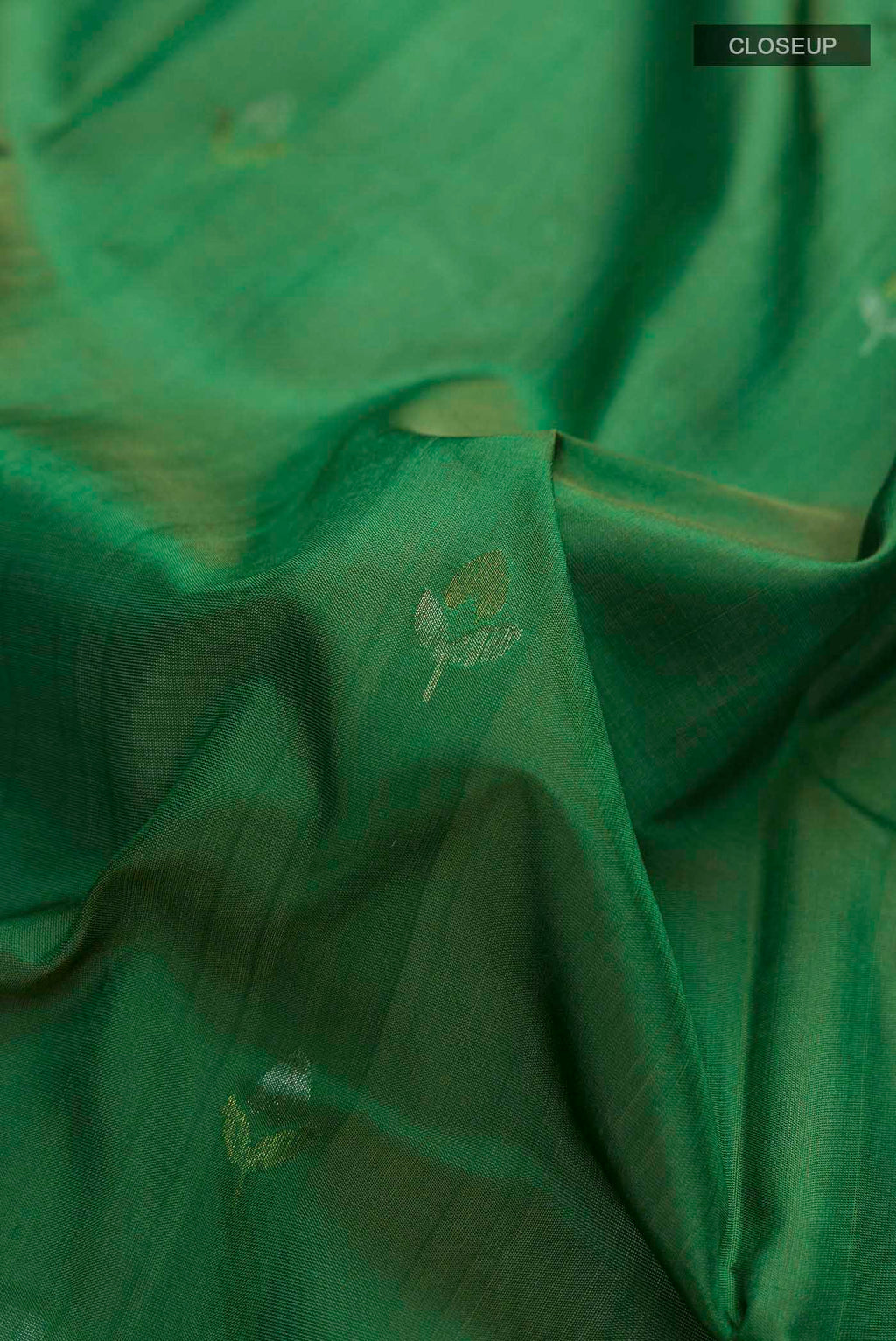 Close up of Green Uppada Silk Saree with Zari Butta on the body and Zari Border displaying folds