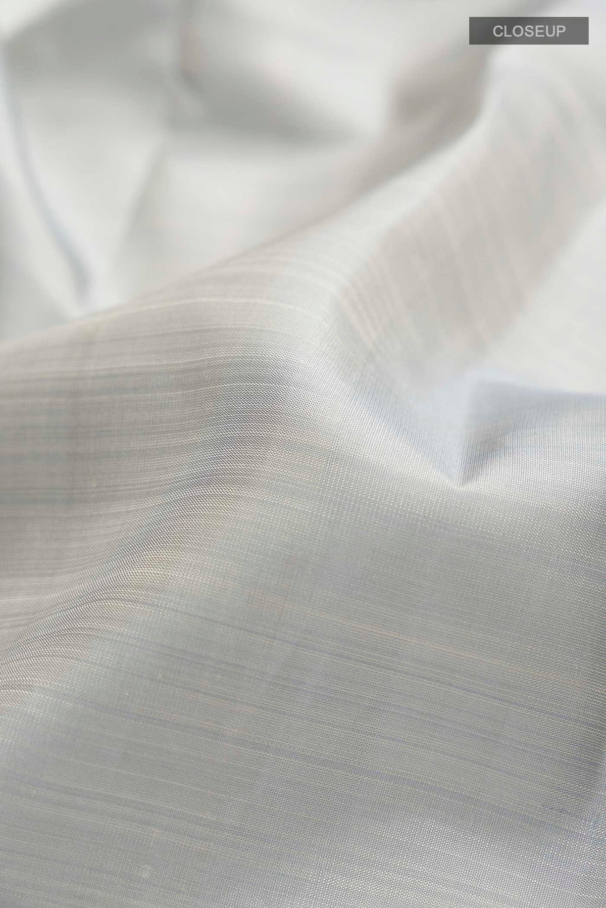 Close up of Grey Kanchipuram Silk Saree with Plain Body and Zari Border displaying folds