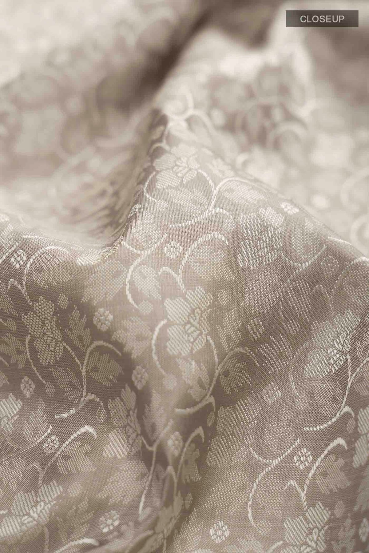 Close up of Grey Kanchipuram Silk Saree with Jacquard design on the body and Zari Border displaying folds