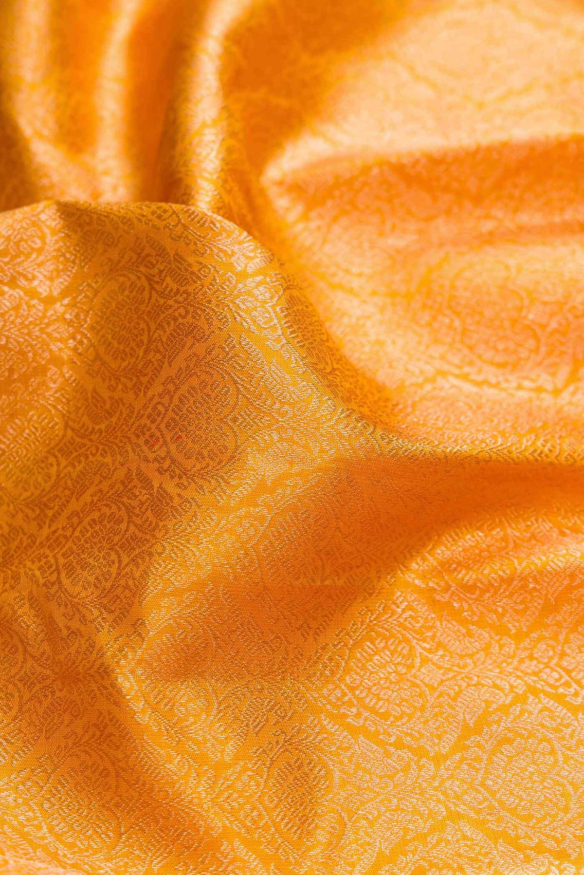Close up of Mustard Dual Tone Kanchipuram Silk Saree with Zari Brocade on the body and Zari Border displaying folds