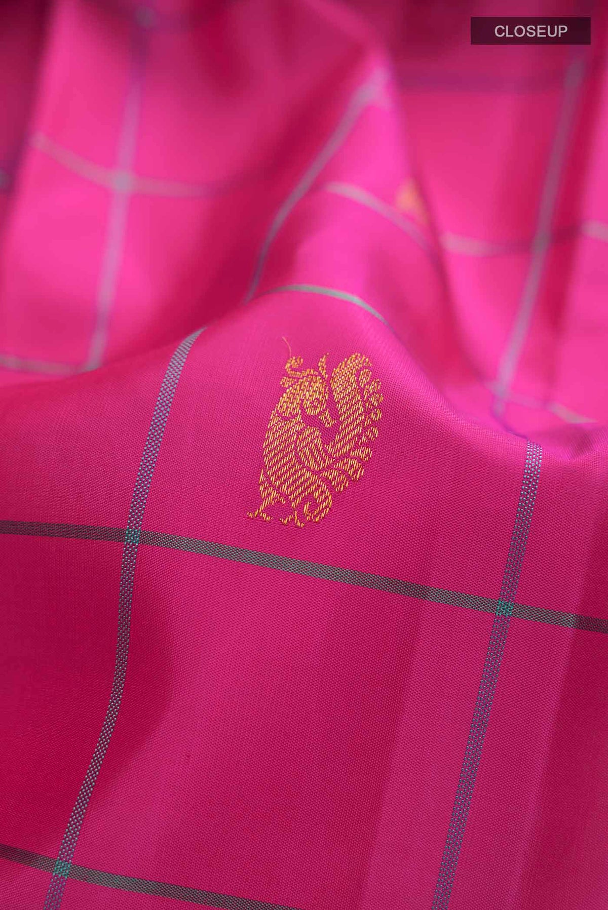 Close up of Pink Kanchipuram Silk Saree with Zari Butta on the body and Plain Border displaying folds