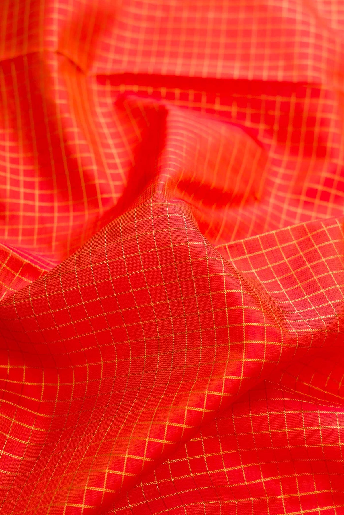 Close up of Pure Silk Pure Zari Orange Dual Tone Kanchipuram Saree with Stripes on the body and Zari Border displaying folds