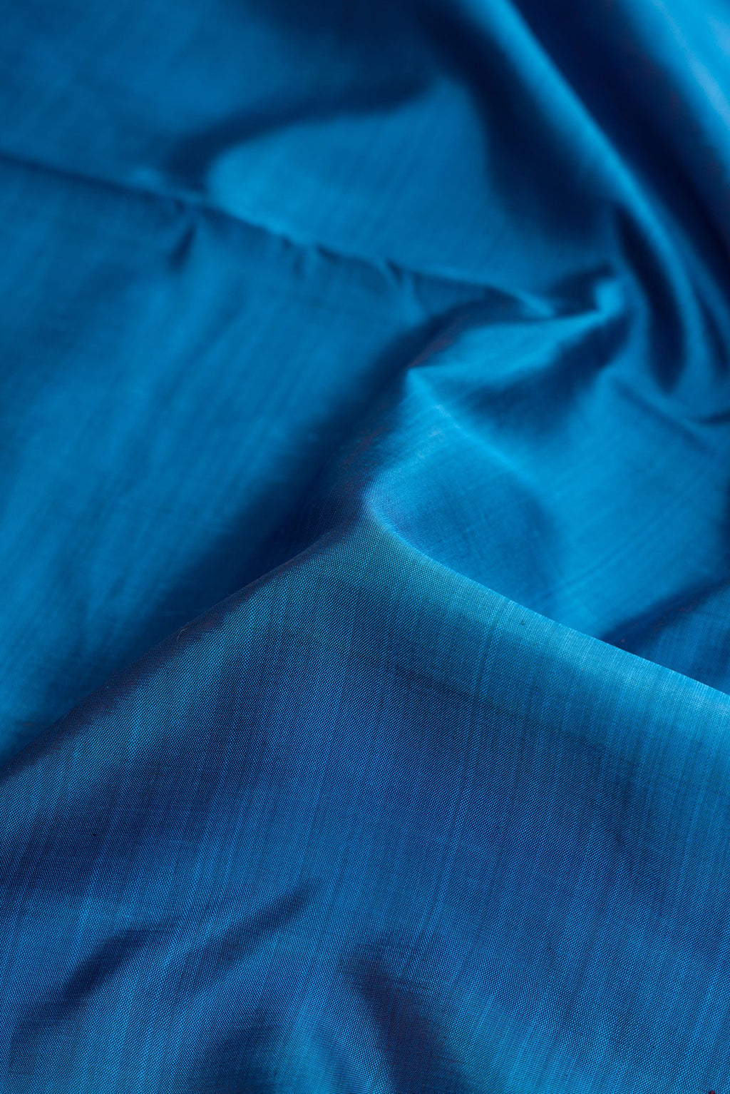 Close up of Pure Silk Pure Zari Peacock Blue Dual Tone Kanjivaram Nine Yards Saree with Plain Body and Zari Border.  displaying folds