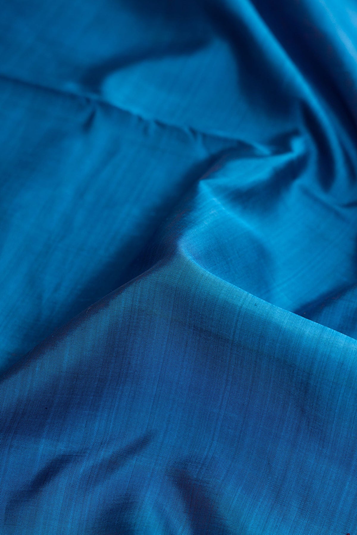 Close up of Pure Silk Pure Zari Peacock Blue Dual Tone Kanjivaram Nine Yards Saree with Plain Body and Zari Border.  displaying folds