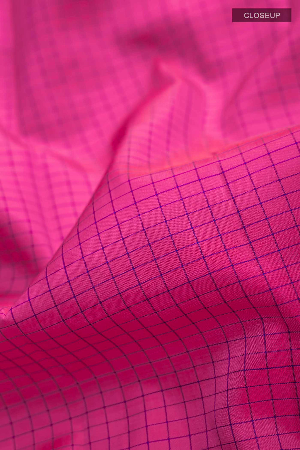 Close up of Pink Kanchipuram Silk Saree with Checked design on the body and Zari Border displaying folds