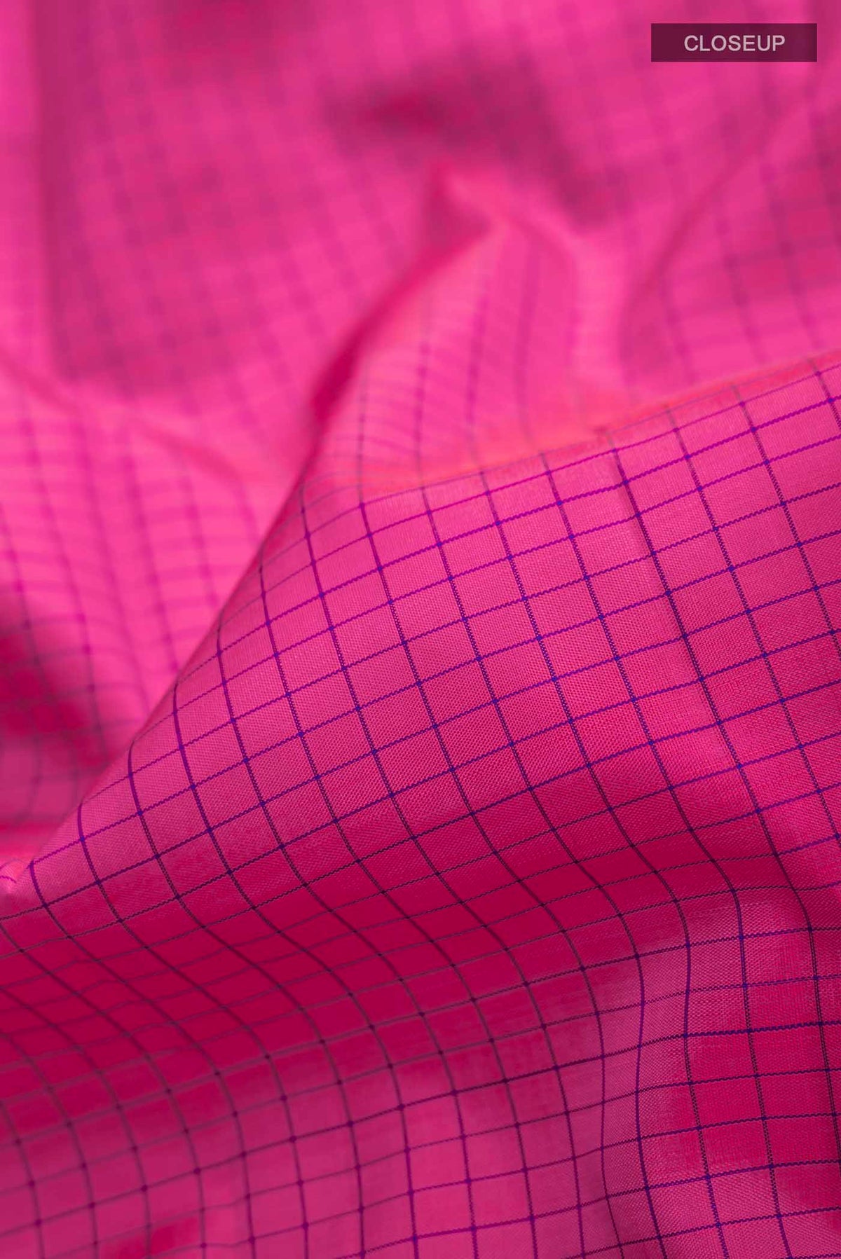 Close up of Pink Kanchipuram Silk Saree with Checked design on the body and Zari Border displaying folds