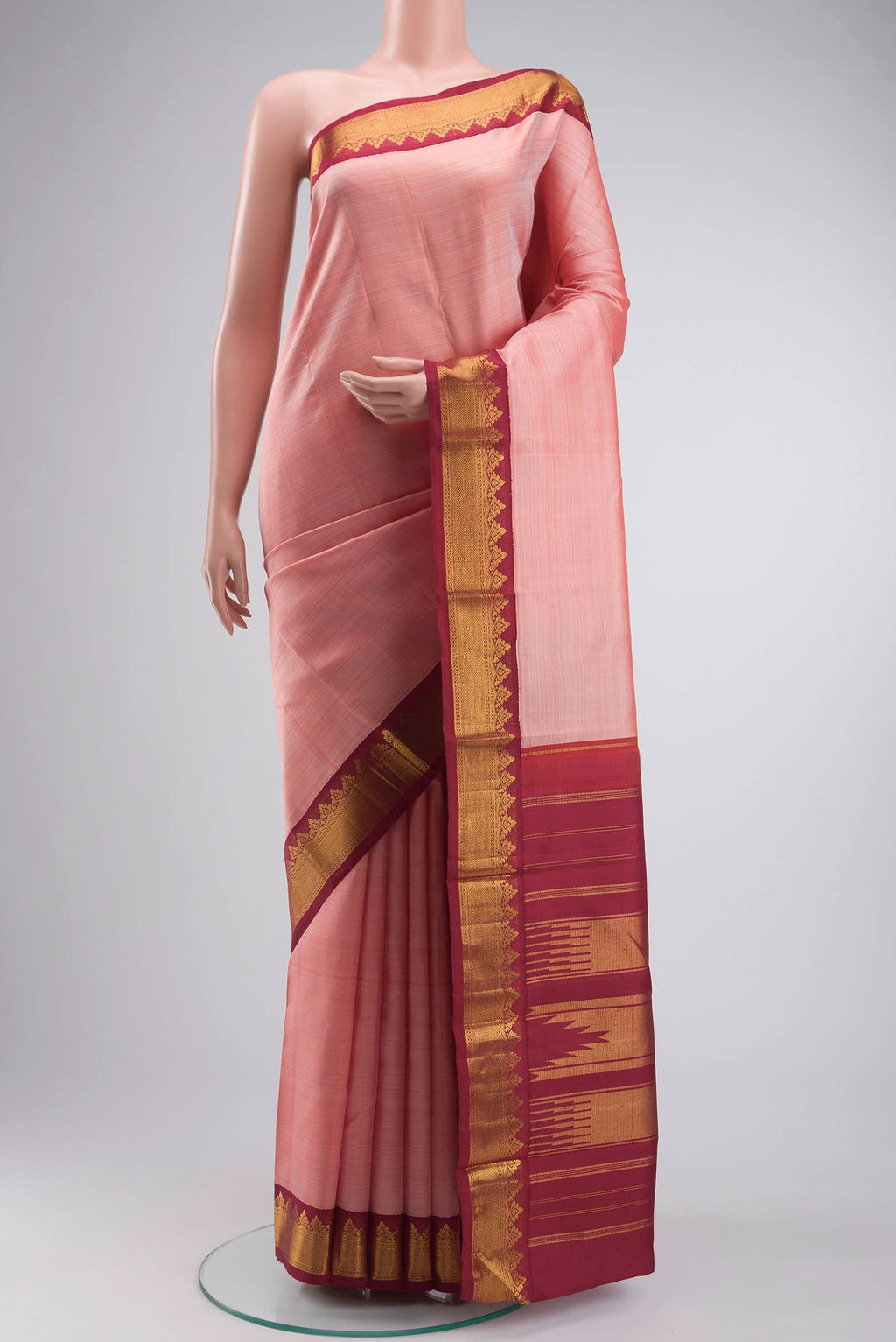 Peach Kanchipuram Silk Saree with Plain Body and Zari Border displayed on a mannequin